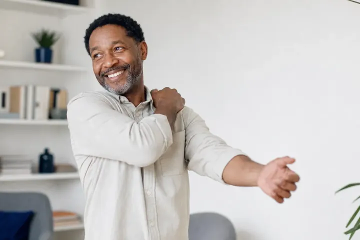 Man tracing radiating nerve pain down his arm before chiropractic treatment for arm and leg pain in Naples FL