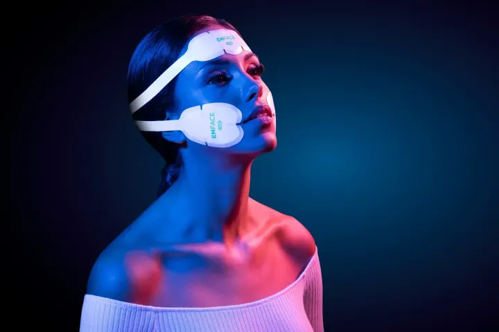 Emface in Naples, FL with the hands-free applicators placed on a patient forehead and cheeks at Bergtold Chiropractic
