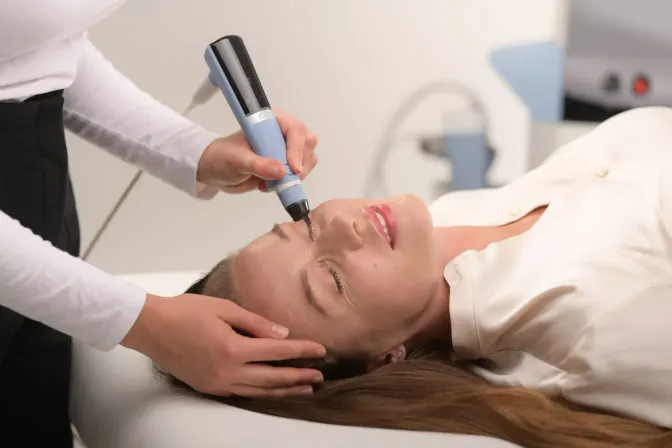 Exion in Naples, FL with the needle-free face applicator gliding over a patient cheek at Bergtold Chiropractic