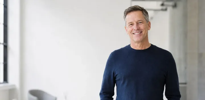 Man bracing his lower back from herniated disc pain before non-surgical treatment in Naples FL